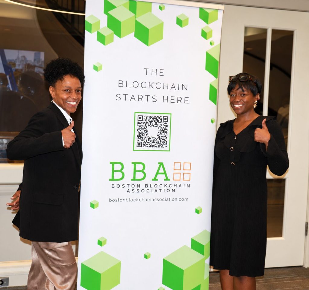 Two BBA volunteers giving a thumbs up beside the BBA banner